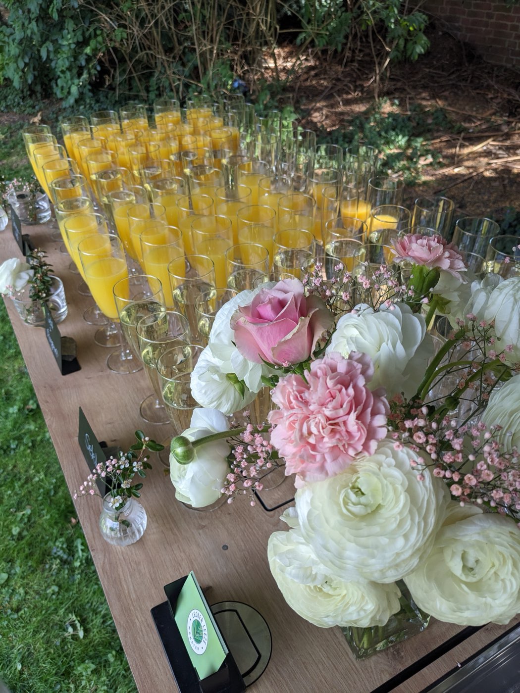 Sekt und Orangensaft mit floraler Deko und Lecker-Leeze-Logo