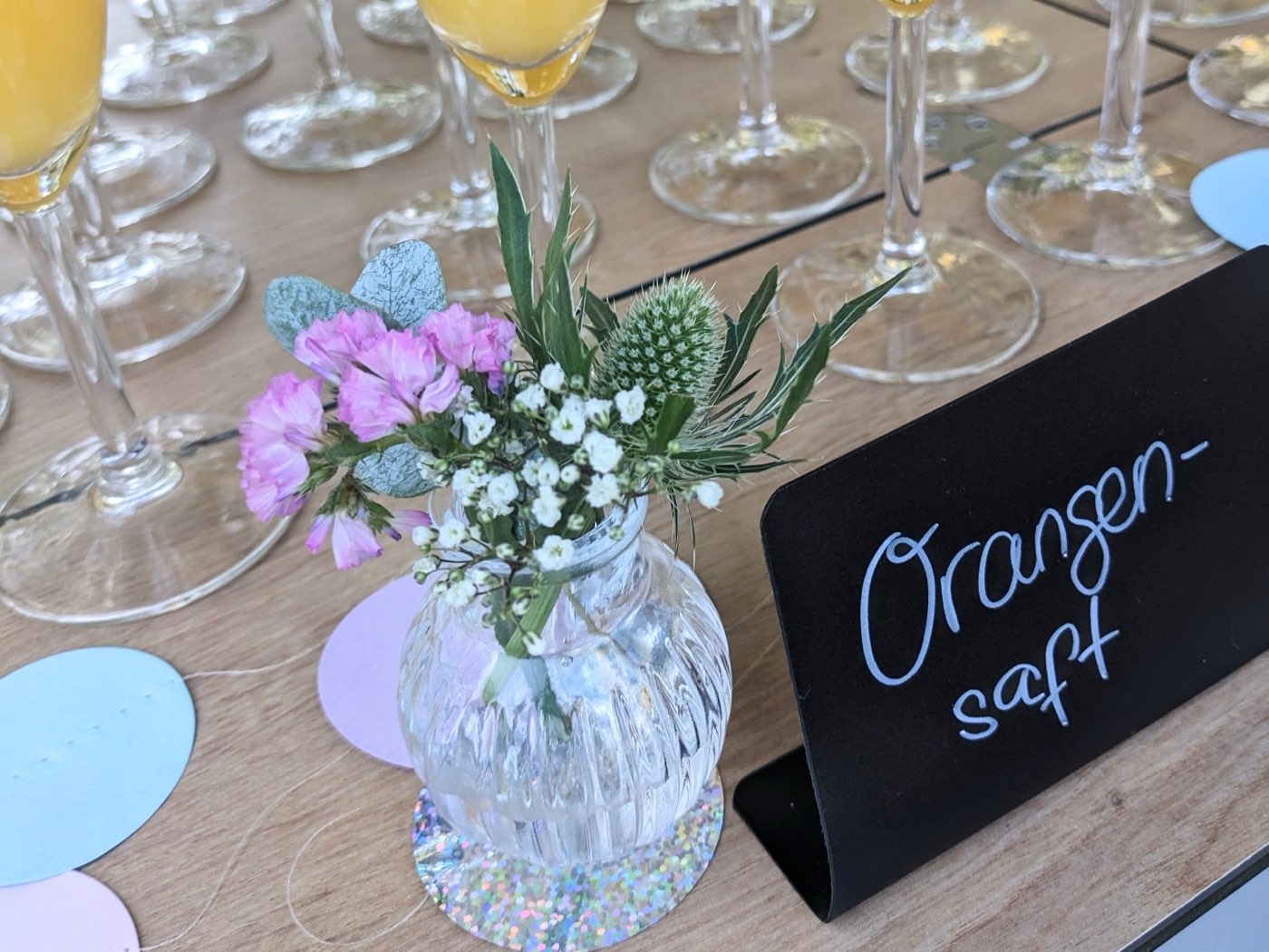 Liebevolle Deko mit Blumen und Kreidetafel am mobilen Sektempfang